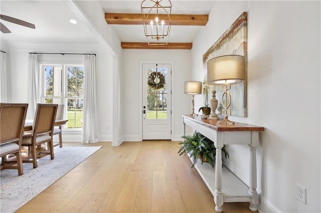 entryway with beamed ceiling, light hardwood / wood-style floors, and ceiling fan with notable chandelier