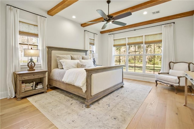 bedroom featuring beamed ceiling, light hardwood / wood-style floors, and ceiling fan