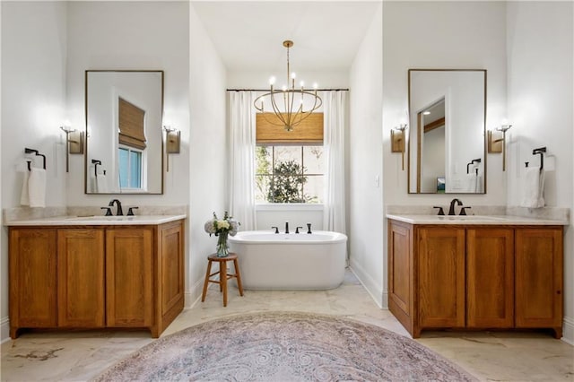 bathroom with vanity, a bath, and a chandelier