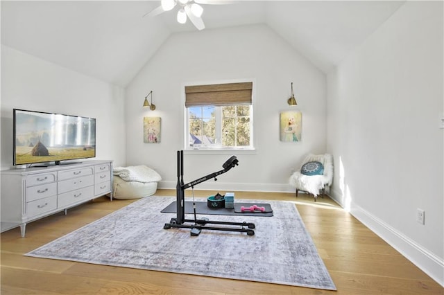 exercise room with light hardwood / wood-style flooring, ceiling fan, and lofted ceiling