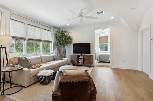 living room featuring light wood-type flooring, ceiling fan, and lofted ceiling