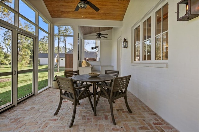 sunroom featuring vaulted ceiling, ceiling fan, and wooden ceiling