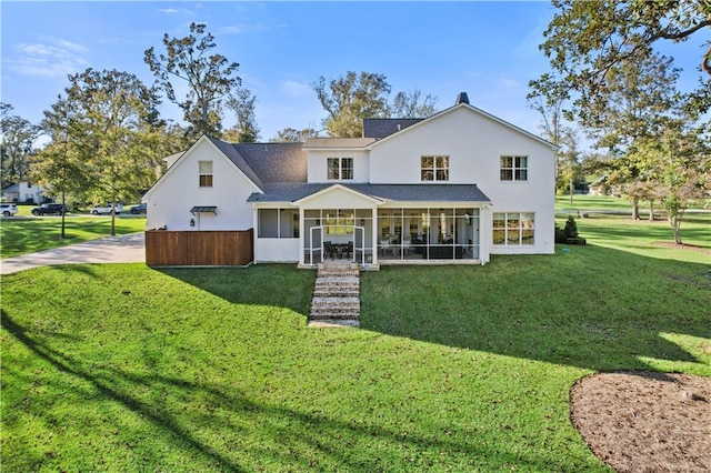 rear view of property with a yard and a sunroom