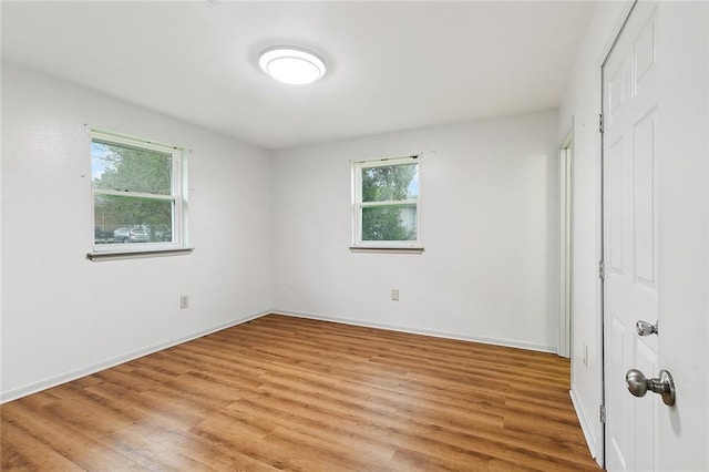 unfurnished bedroom featuring light wood-type flooring and multiple windows