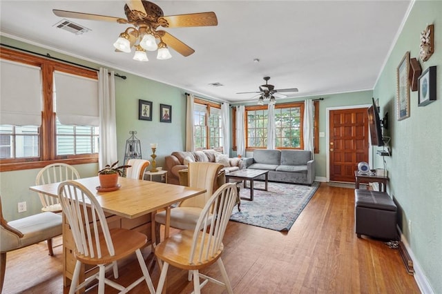 dining room featuring light hardwood / wood-style flooring, ornamental molding, and ceiling fan