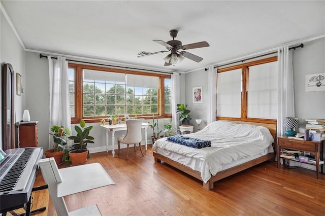 bedroom with crown molding, hardwood / wood-style flooring, and ceiling fan