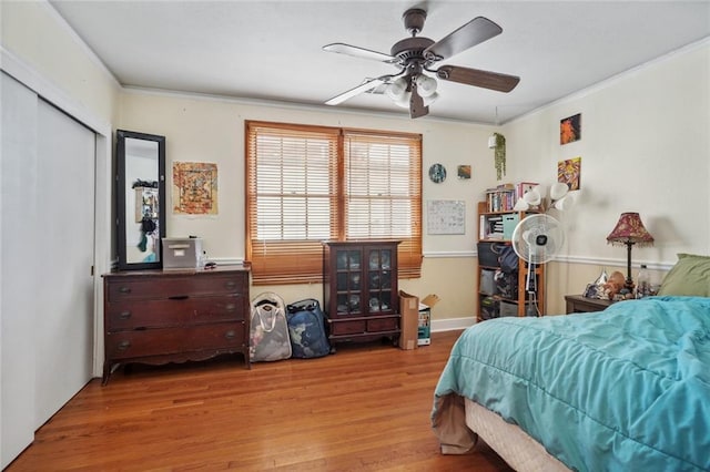 bedroom featuring crown molding, light hardwood / wood-style floors, and ceiling fan