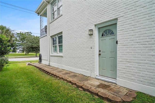 view of exterior entry featuring a yard