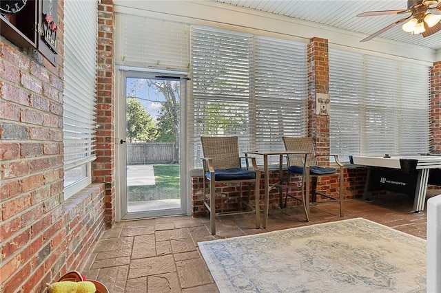 unfurnished sunroom with ceiling fan