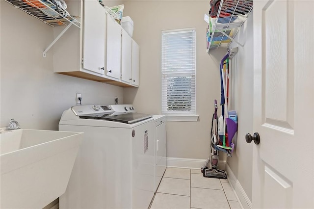 laundry room featuring cabinets, washing machine and clothes dryer, sink, and light tile patterned floors