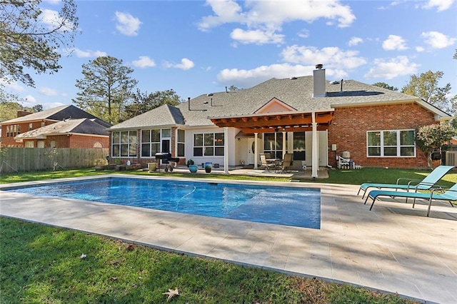 view of swimming pool with a patio, area for grilling, a lawn, and a pergola