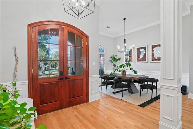 entrance foyer with hardwood / wood-style flooring, ornamental molding, and a chandelier