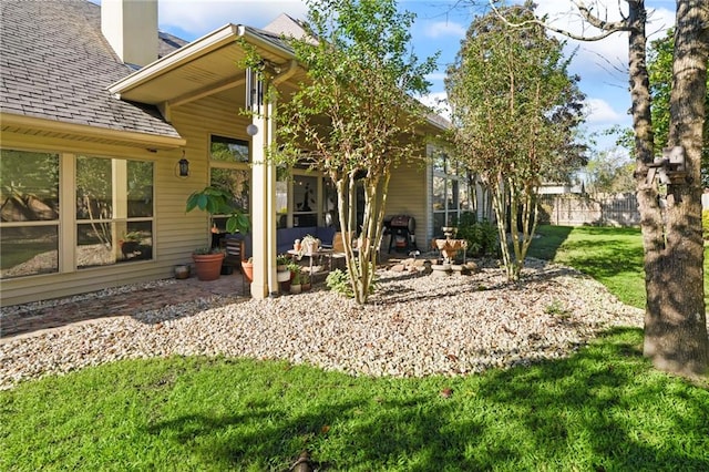 rear view of property with a lawn and a patio