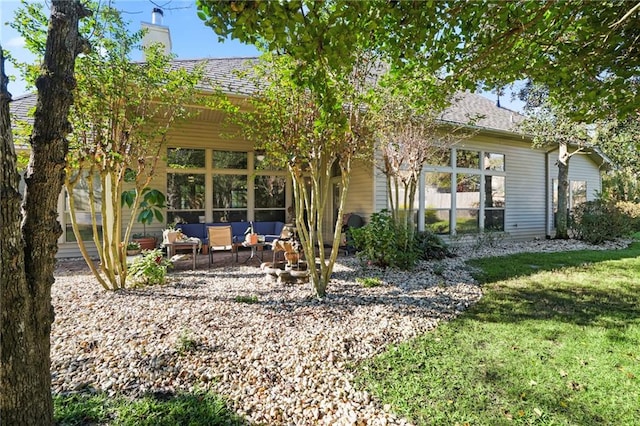 back of property with a lawn and an outdoor hangout area