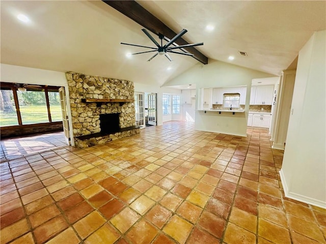 unfurnished living room with lofted ceiling with beams, ceiling fan, light tile patterned floors, and a fireplace