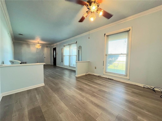 unfurnished living room with ceiling fan with notable chandelier, ornamental molding, and dark wood-type flooring