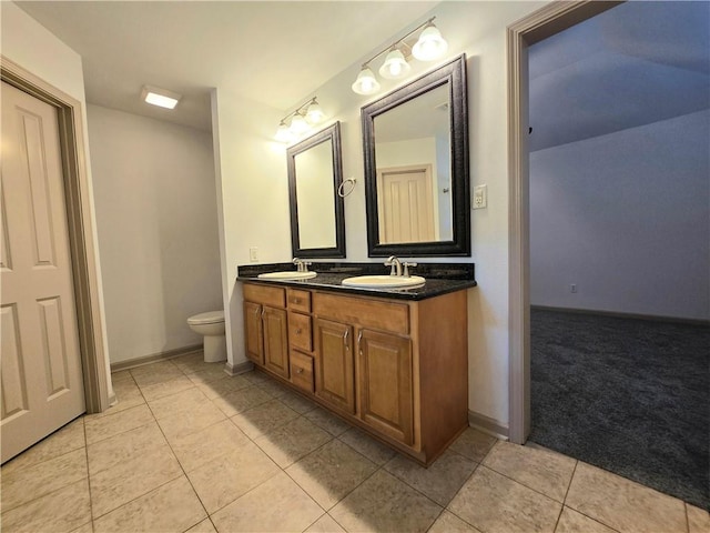 bathroom with tile patterned flooring, vanity, and toilet