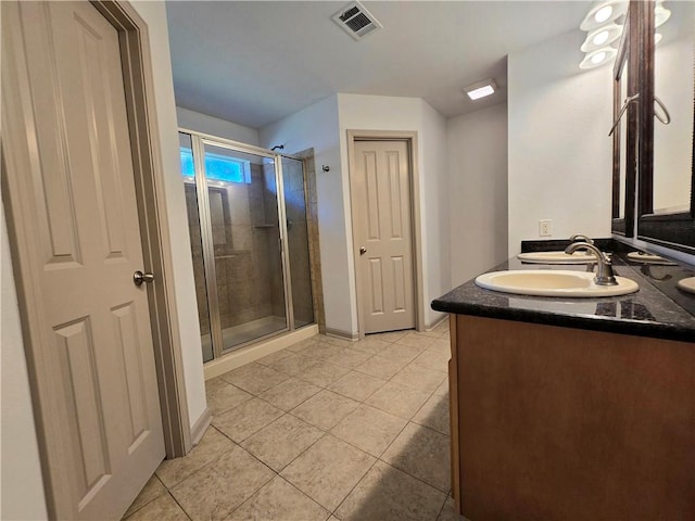 bathroom with tile patterned flooring, vanity, and walk in shower