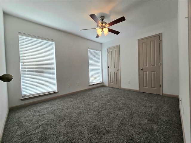 interior space featuring two closets, dark carpet, and ceiling fan