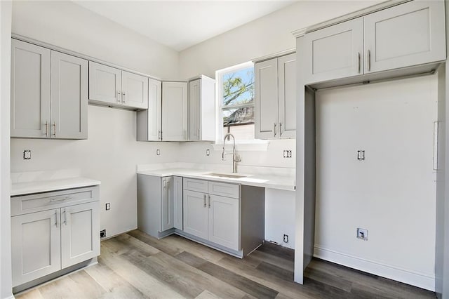 kitchen featuring gray cabinets, light hardwood / wood-style flooring, and sink