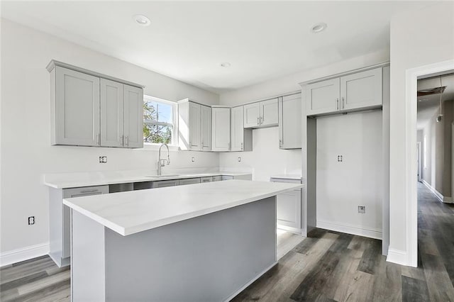 kitchen featuring gray cabinetry, a center island, and dark wood-type flooring