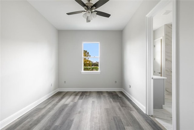 empty room with ceiling fan and light hardwood / wood-style floors