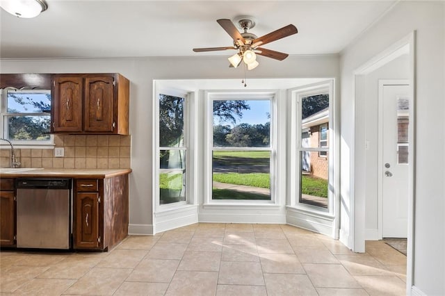 kitchen featuring ceiling fan, dishwasher, sink, tasteful backsplash, and light tile patterned floors