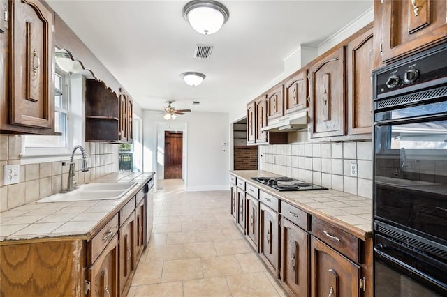 kitchen featuring tile counters, sink, tasteful backsplash, stovetop, and black double oven