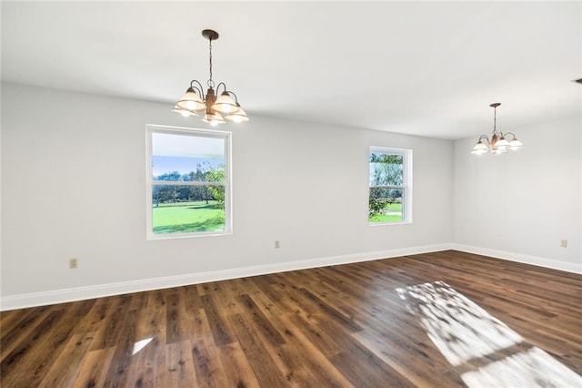 unfurnished room with dark wood-type flooring and an inviting chandelier