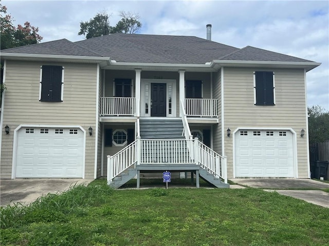 view of front facade featuring covered porch, a garage, and a front lawn