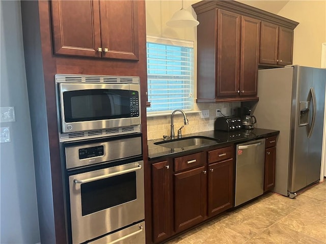 kitchen with pendant lighting, sink, stainless steel appliances, and tasteful backsplash