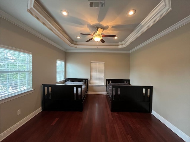 bedroom featuring a tray ceiling, ceiling fan, dark hardwood / wood-style floors, and ornamental molding