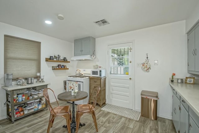 kitchen with white appliances, light hardwood / wood-style floors, and gray cabinets