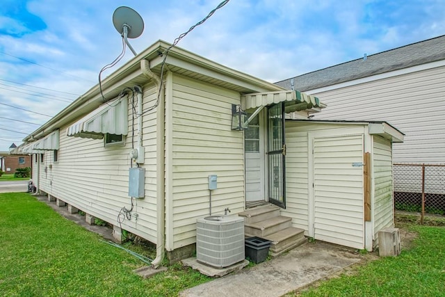 view of property exterior featuring a lawn and central air condition unit