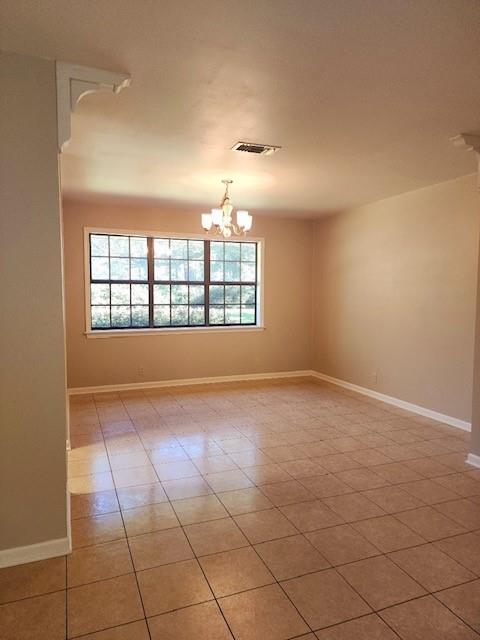 empty room with a wealth of natural light and an inviting chandelier