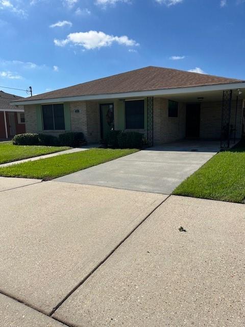 single story home featuring a front yard and a carport