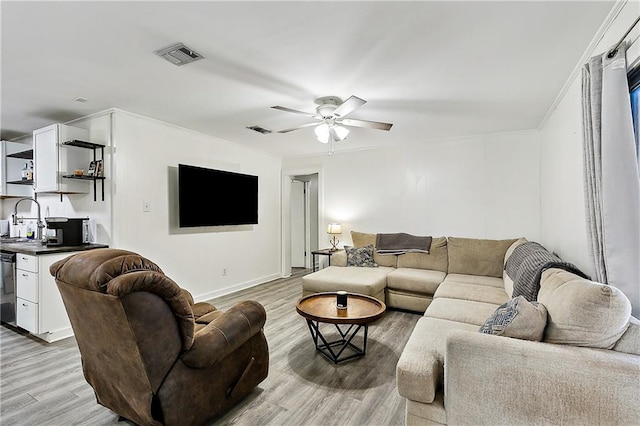 living room with ceiling fan, light wood-type flooring, and sink