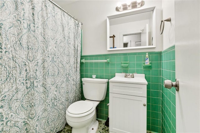 bathroom with vanity, tile patterned floors, a shower with curtain, toilet, and tile walls