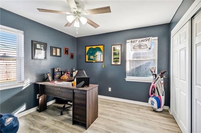 home office with light hardwood / wood-style floors and ceiling fan