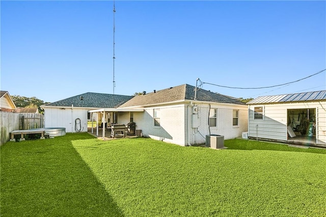 back of property with cooling unit, a yard, and a patio