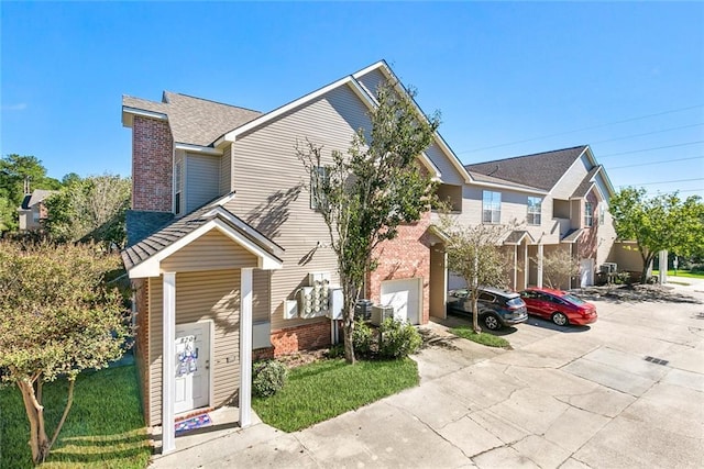 517 Spartan Dr Unit 8206, Slidell, LA 70458 - view of property with brick siding, a garage, roof with shingles, and driveway