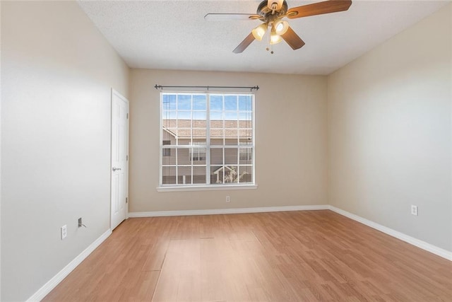 spare room featuring ceiling fan, light hardwood / wood-style flooring, and a textured ceiling