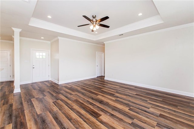 unfurnished room with dark hardwood / wood-style floors, a raised ceiling, and ornamental molding