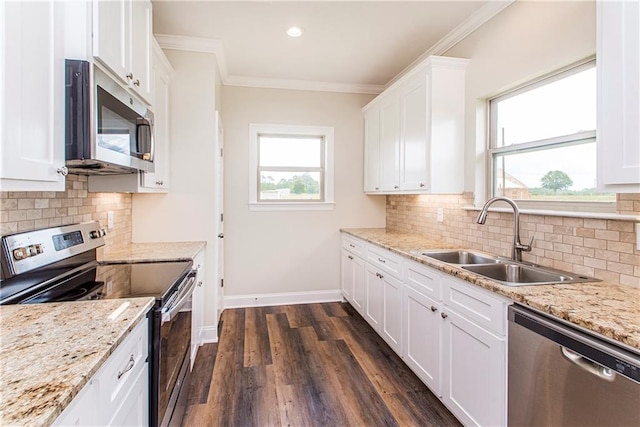 kitchen with white cabinetry, sink, dark hardwood / wood-style flooring, appliances with stainless steel finishes, and ornamental molding