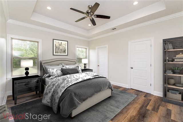 bedroom with ceiling fan, dark hardwood / wood-style floors, a raised ceiling, and multiple windows