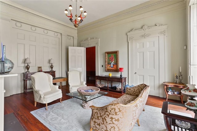 living area featuring hardwood / wood-style floors, a notable chandelier, and crown molding