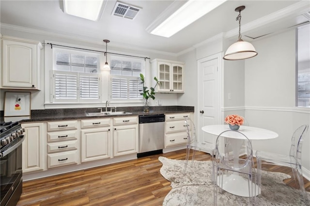 kitchen featuring crown molding, sink, light hardwood / wood-style flooring, appliances with stainless steel finishes, and decorative light fixtures