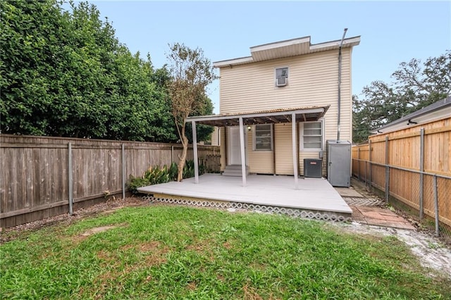 rear view of house featuring a lawn, cooling unit, and a wooden deck