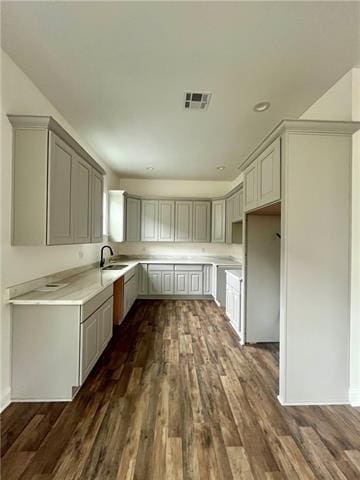 kitchen with dark hardwood / wood-style flooring, gray cabinets, and sink