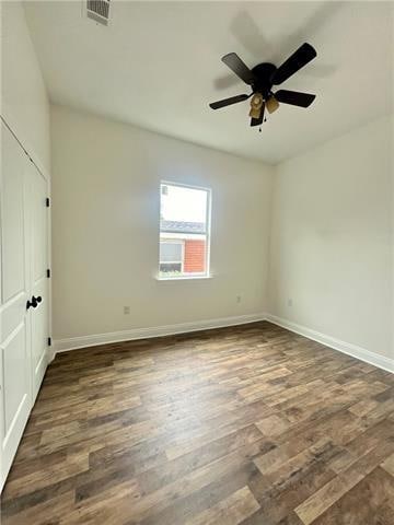 empty room with ceiling fan and dark wood-type flooring